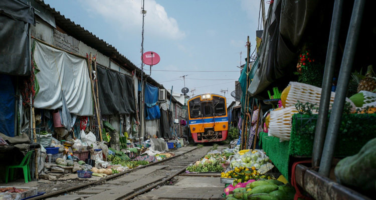 The train passes through market in Thailand