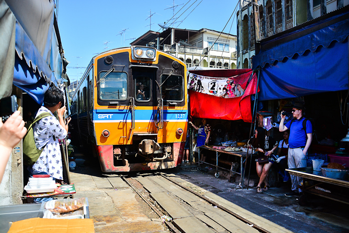Train passing through Maeklong Railway Market | train trips from Bangkok | Bangkok Food Tours